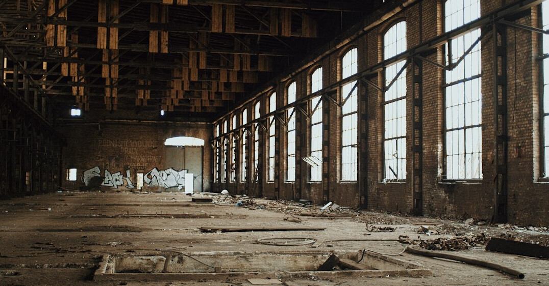 Interior of an abandoned industrial warehouse with broken windows